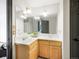 Bathroom with double sinks, wooden cabinets, large mirror, and good lighting at 24 Pine Valley Rd, Evergreen, CO 80439