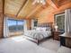 This bedroom features wood plank walls and beautiful mountain views from two large windows at 24 Pine Valley Rd, Evergreen, CO 80439
