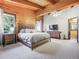 Spacious primary bedroom features wood plank walls, plush carpet, and plenty of natural light at 24 Pine Valley Rd, Evergreen, CO 80439