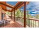 Deck featuring wood floors, a partial roof, and view of surrounding trees at 24 Pine Valley Rd, Evergreen, CO 80439