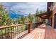 Exterior deck with wood floors and metal railings overlooking the forest at 24 Pine Valley Rd, Evergreen, CO 80439