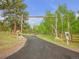 Scenic driveway leading to the property, framed by trees and a wooden gate at 24 Pine Valley Rd, Evergreen, CO 80439