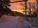 Entryway view of property, showcasing a scenic drive and vibrant sunset at 24 Pine Valley Rd, Evergreen, CO 80439