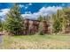 Exterior shot of a well-maintained two story wooden home with lush green lawn at 24 Pine Valley Rd, Evergreen, CO 80439