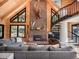 Cozy living room boasts vaulted ceilings, stone fireplace and spiral staircase at 24 Pine Valley Rd, Evergreen, CO 80439