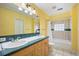 Bright bathroom featuring double sinks with dark green countertops, and a shower-tub combination with patterned tiles at 2432 S Columbine St, Denver, CO 80210