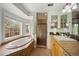 Bright bathroom with a large soaking tub, shower, vanity and a large window offering natural light and views at 2432 S Columbine St, Denver, CO 80210