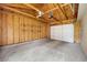 A large, unfinished garage with a concrete floor and a white garage door at 2432 S Columbine St, Denver, CO 80210