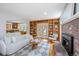 Inviting living room with brick fireplace, built in shelves, and view into the open kitchen and light from french doors at 2432 S Columbine St, Denver, CO 80210