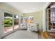 Bright sun room featuring two cozy chairs, a small side table, and a glass door to the backyard at 2432 S Columbine St, Denver, CO 80210