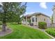 Well-maintained backyard featuring lush green grass, mature trees, and a covered patio for outdoor living at 1051 Bramblewood Dr, Castle Pines, CO 80108
