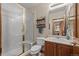Well-lit bathroom featuring a glass shower, vanity with storage, and neutral-toned walls with updated fixtures at 1051 Bramblewood Dr, Castle Pines, CO 80108