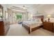 Spacious primary bedroom with a large bay window, ceiling fan, and an ensuite bathroom at 1051 Bramblewood Dr, Castle Pines, CO 80108