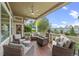 Spacious covered patio featuring outdoor seating, a ceiling fan, and a view of the professionally landscaped backyard at 1051 Bramblewood Dr, Castle Pines, CO 80108