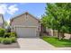 Charming home boasts a landscaped front yard, mature trees, and an attached two car garage at 1051 Bramblewood Dr, Castle Pines, CO 80108