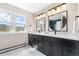 Modern bathroom features double sinks, sleek black cabinets, and mountain views at 8451 London Ln, Conifer, CO 80433