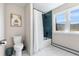 Bright bathroom with a white tile floor, blue tiled shower and picturesque window view at 8451 London Ln, Conifer, CO 80433