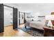 Cozy bedroom with wood floors, an area rug, and sliding barn door to a walk-in closet at 8451 London Ln, Conifer, CO 80433