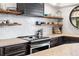 Close up of kitchen featuring stainless appliances, stone countertops, and floating shelves at 8451 London Ln, Conifer, CO 80433