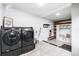 Laundry room with modern washer/dryer, white tile and shelving at 8451 London Ln, Conifer, CO 80433