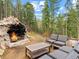 Outdoor living space with an outdoor fireplace and views of the beautiful forest at 8451 London Ln, Conifer, CO 80433