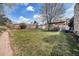 Spacious backyard features a well-maintained lawn, a patio area, and mature trees providing ample shade at 13036 Clayton Ct, Thornton, CO 80241