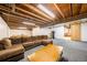 Basement featuring carpeting, a sectional couch, table and exposed ceiling at 13036 Clayton Ct, Thornton, CO 80241