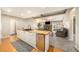 Modern kitchen featuring an island with butcher block countertop with the living room in the background at 13036 Clayton Ct, Thornton, CO 80241