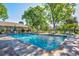 Large, inviting outdoor swimming pool surrounded by mature trees and lounge chairs at 2804 S Heather Gardens Way # A, Aurora, CO 80014