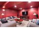 Finished basement with large red accent wall and comfortable seating area at 2032 W Nantucket Ct, Littleton, CO 80120