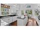 Bright kitchen featuring white cabinets, black countertops, an island, and a breakfast nook with backyard view at 2032 W Nantucket Ct, Littleton, CO 80120