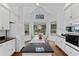 Eat-in kitchen features white cabinets, black countertops, an island with cooktop, and bright backyard views at 2032 W Nantucket Ct, Littleton, CO 80120