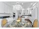 Bright eat-in kitchen with white cabinetry, black countertops, stainless appliances, and island with cooktop at 2032 W Nantucket Ct, Littleton, CO 80120