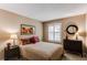 Bedroom featuring a floral bedspread, shuttered window, and wood dresser at 8109 E Phillips Cir, Centennial, CO 80112