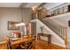 Elegant dining room with a classic wooden table set for a meal, adjacent to a staircase and bright kitchen at 8109 E Phillips Cir, Centennial, CO 80112