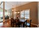 Warm dining area with a rustic table set for dinner, wood floors, and bright, natural lighting from shuttered windows at 8109 E Phillips Cir, Centennial, CO 80112