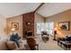 Inviting living room with vaulted ceiling, brick fireplace, comfortable seating and natural light from shuttered windows at 8109 E Phillips Cir, Centennial, CO 80112