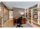 Bright office featuring a large desk, chair and custom shelving. with a hallway adjacent at 8109 E Phillips Cir, Centennial, CO 80112