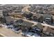 An aerial view showcases a neighborhood with muted color homes, winter trees, and sparse snowy lawns at 16510 Buckthorn Ln, Parker, CO 80134