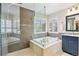 Bathroom featuring a glass shower, soaking tub under shuttered windows, and modern vanity at 2090 Bellavista St, Castle Rock, CO 80109