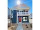 Charming two-story home featuring a balcony, a red front door, and low-maintenance landscaping at 45016 Sunflower Ln, Bennett, CO 80102