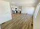 Open-concept living space flows into a modern kitchen with stainless steel appliances and white cabinetry at 45016 Sunflower Ln, Bennett, CO 80102