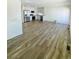 Open-concept living space flows into a modern kitchen with stainless steel appliances and white cabinetry at 45016 Sunflower Ln, Bennett, CO 80102