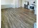 Open-concept living room with wood-look floors leading into the kitchen and stairway at 45016 Sunflower Ln, Bennett, CO 80102