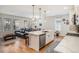 Open-concept layout features a kitchen island leading into a cozy living room with a leather sofa at 1962 Canyonpoint Ln, Castle Pines, CO 80108
