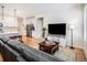 Cozy living room with a leather sofa, entertainment center, and open view to the modern kitchen at 1962 Canyonpoint Ln, Castle Pines, CO 80108