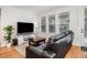 Inviting living room features a leather sofa, entertainment center, and ample natural light from large windows at 1962 Canyonpoint Ln, Castle Pines, CO 80108
