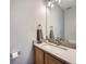 Modern bathroom featuring a light countertop, wood vanity, faucet, and large mirror at 19098 E Ida Dr, Aurora, CO 80015