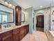 Elegant bathroom with dual sinks, granite countertops, walk-in shower, and custom wood cabinets at 19098 E Ida Dr, Aurora, CO 80015