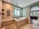 Gorgeous bathroom featuring a glass shower, a large soaking tub, and tiled walls with a mosaic design at 19098 E Ida Dr, Aurora, CO 80015